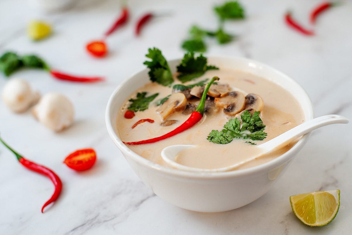 vegan tom kha soup with fresh herb toppings